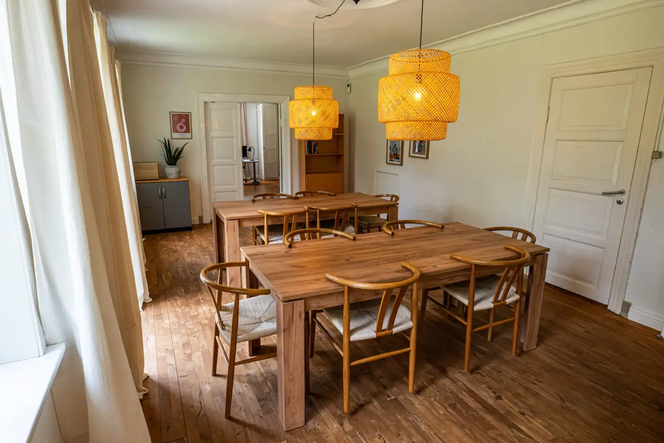 Det lange spisebord på Faurholt under to pendler, hvor husets måltider holdes